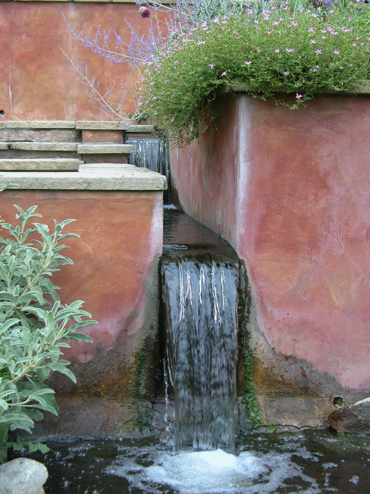 A waterfall from a terrace and rill drops into an informal stream with staged biofilters