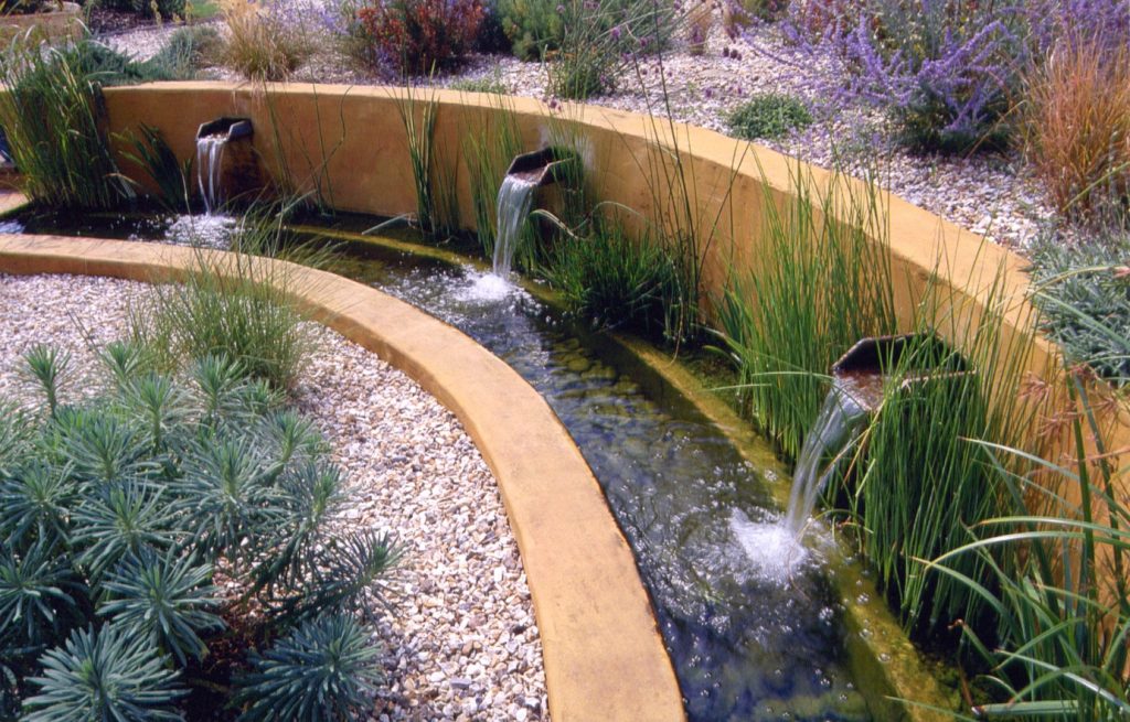 This small rill incorporates a bio-filter alongside the wall. Spouts pour water into the filter, where it is cleansed before being passed back into the rill.